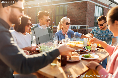 Image of friends having dinner or bbq party on rooftop