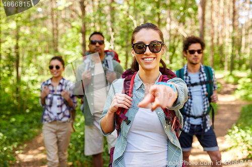 Image of friends with backpacks on hike in forest