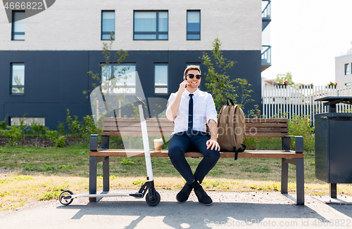 Image of businessman with scooter calling on smartphone