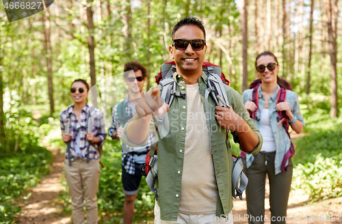 Image of friends with backpacks on hike in forest