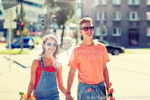 Image of teenage couple with skateboards on city street