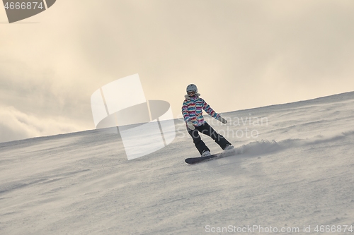 Image of Female snowboarder in sun flare