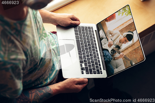 Image of Man watching online music concert at home during insulation, COVID-19 quarantine