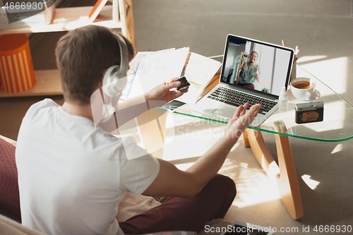 Image of Man working from home, remote office concept. Young businessman, manager doing tasks with laptop, has online conference.