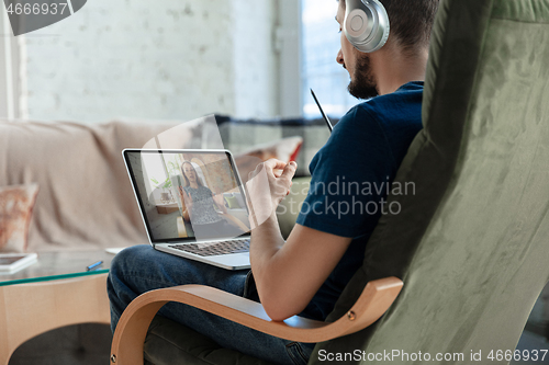 Image of Man working from home, remote office concept. Young businessman, manager doing tasks with laptop, has online conference.