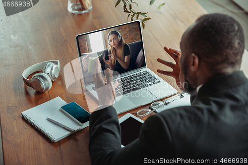 Image of Man working from home, remote office concept. Young businessman, manager doing tasks with laptop, has online conference.