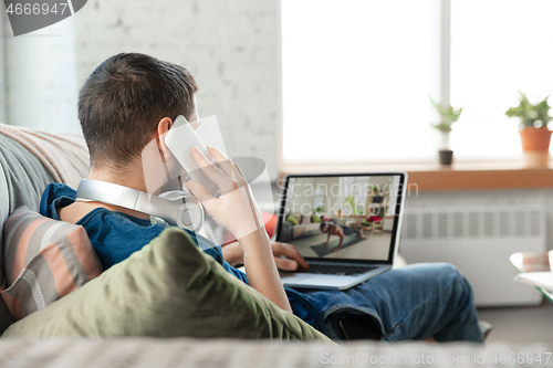 Image of Man working from home, remote office concept. Young businessman, manager doing tasks with laptop, has online conference.