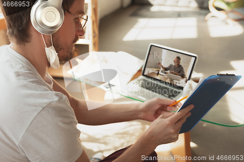 Image of Man working from home, remote office concept. Young businessman, manager doing tasks with laptop, has online conference.