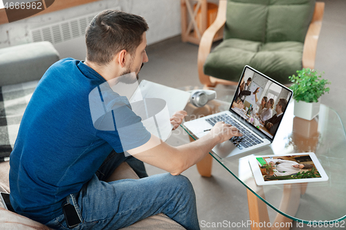 Image of Man working from home, remote office concept. Young businessman, manager doing tasks with laptop, has online conference.