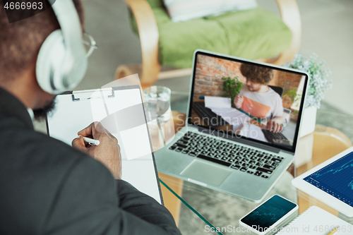 Image of Man working from home, remote office concept. Young businessman, manager doing tasks with laptop, has online conference.