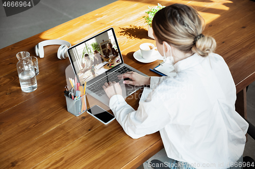 Image of Young doctor working online with laptop, has online conference with colleagues from workplace