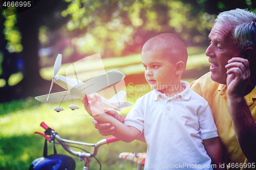 Image of grandfather and child have fun  in park