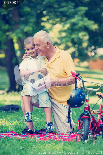 Image of grandfather and child have fun  in park