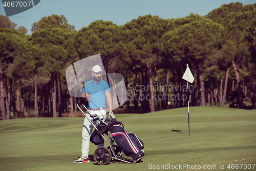 Image of golf player walking with wheel bag