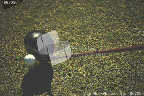 Image of golf club and ball in grass