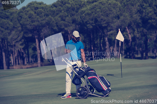 Image of golf player walking with wheel bag