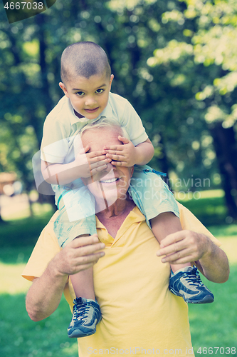 Image of grandfather and child have fun  in park