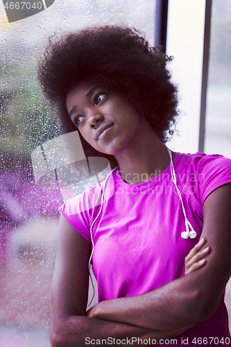 Image of portrait of young afro american woman in gym while listening mus