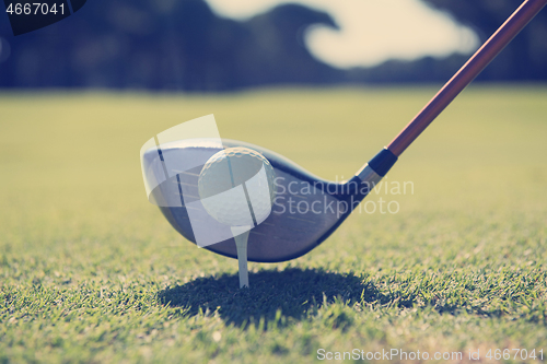 Image of golf player placing ball on tee