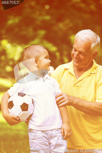 Image of grandfather and child have fun  in park