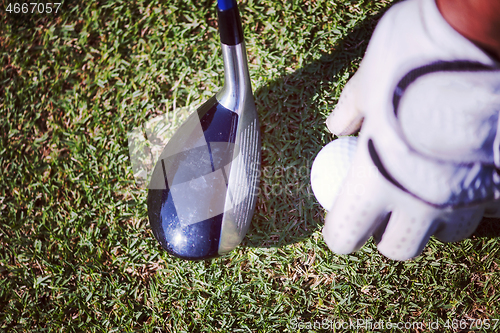 Image of golf club and ball in grass