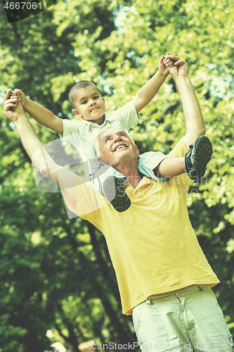 Image of grandfather and child have fun  in park