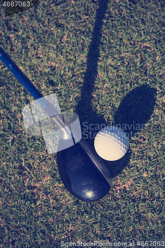 Image of top view of golf club and ball in grass