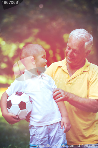 Image of grandfather and child have fun  in park