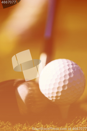 Image of golf club and ball in grass