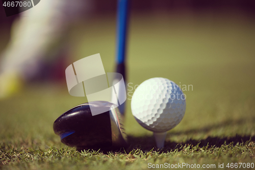 Image of golf club and ball in grass