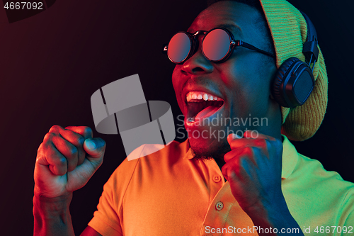 Image of The young handsome hipster man listening music with headphones