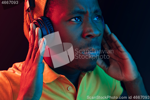 Image of The young handsome hipster man listening music with headphones