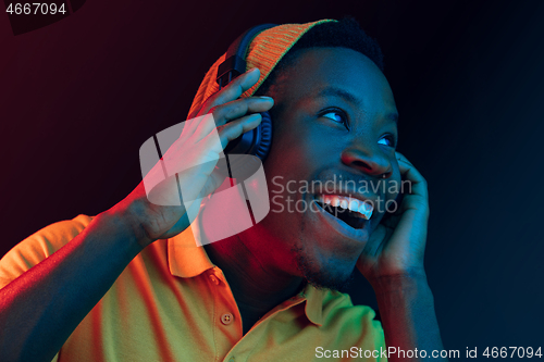 Image of The young handsome hipster man listening music with headphones