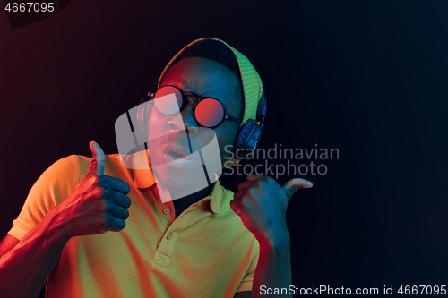 Image of The young handsome hipster man listening music with headphones