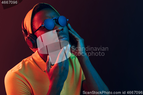 Image of The young handsome hipster man listening music with headphones