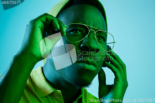 Image of The young handsome hipster man listening music with headphones