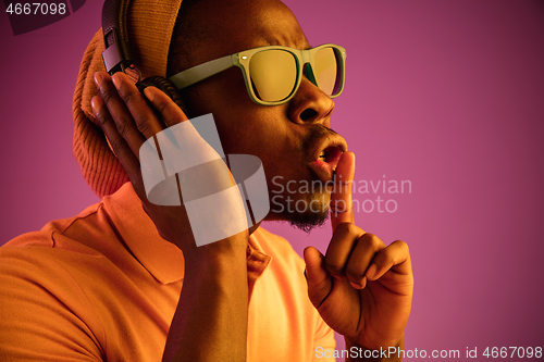 Image of The young handsome hipster man listening music with headphones