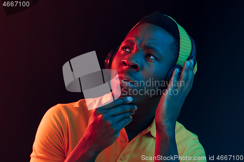Image of The young handsome hipster man listening music with headphones