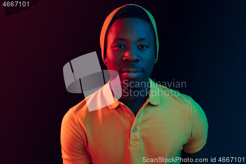 Image of Portrait of a happy young african american man smiling on black neon background