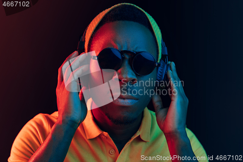 Image of The young handsome hipster man listening music with headphones