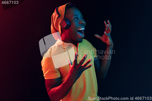 Image of The young handsome hipster man listening music with headphones