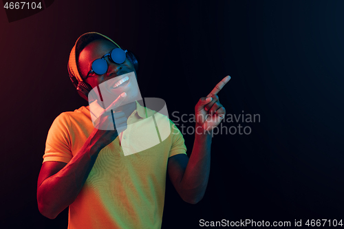 Image of The young handsome hipster man listening music with headphones