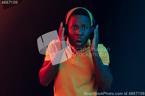 Image of The young handsome hipster man listening music with headphones