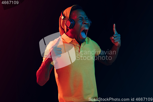 Image of The young handsome hipster man listening music with headphones