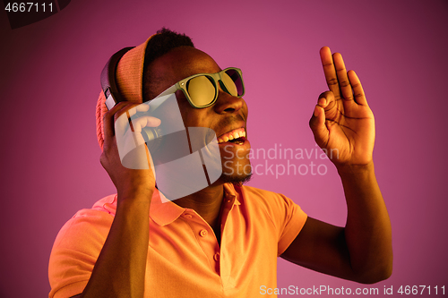 Image of The young handsome hipster man listening music with headphones