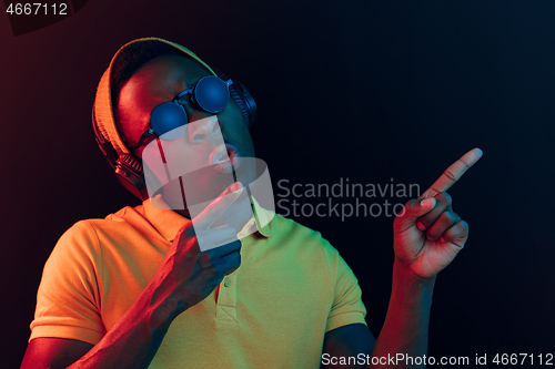 Image of The young handsome hipster man listening music with headphones