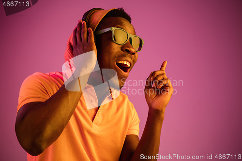 Image of The young handsome hipster man listening music with headphones