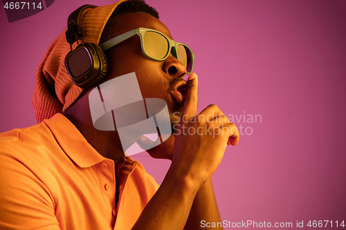 Image of The young handsome hipster man listening music with headphones