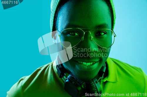 Image of Portrait of a happy young african american man smiling on black neon background