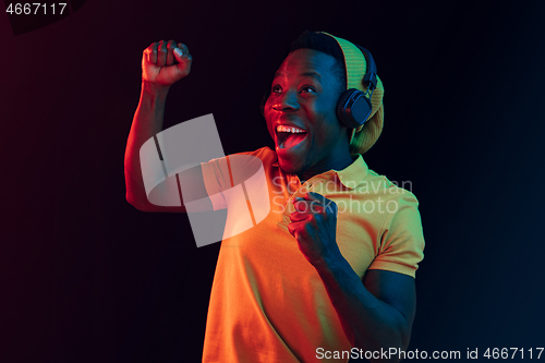 Image of The young handsome hipster man listening music with headphones